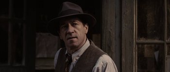 Movie still from “Cinderella Man” (2005), directed by Ron Howard – A person wearing a hat and a vest; Close Up shot, Over the shoulder angle