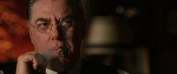 Movie still from “Cinderella Man” (2005), directed by Ron Howard – An older man wearing glasses smoking a cigarette; Close Up shot, Low angle