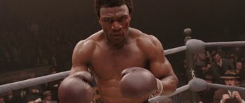 Movie still from “Cinderella Man” (2005), directed by Ron Howard – A man in a boxing ring with his hands in the air; Medium shot, Low angle
