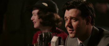 Movie still from “Cinderella Man” (2005), directed by Ron Howard – A man and a woman singing into microphones; Close Up shot, Over the shoulder angle