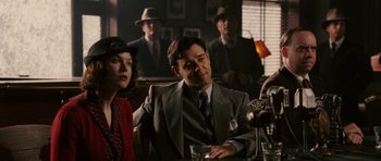 Movie still from “Cinderella Man” (2005), directed by Ron Howard – A man and a woman sitting in front of a microphone; Medium shot, Over the shoulder angle