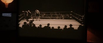 Movie still from “Cinderella Man” (2005), directed by Ron Howard – A boxing match in a boxing ring with spectators watching it; Wide shot, High angle