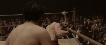 Movie still from “Cinderella Man” (2005), directed by Ron Howard – A man in a boxing ring getting ready for a fight; Medium shot, High angle