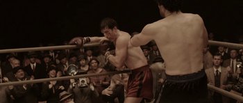 Movie still from “Cinderella Man” (2005), directed by Ron Howard – Two men are boxing in front of an audience; Medium shot, High angle