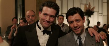 Movie still from “Cinderella Man” (2005), directed by Ron Howard – A man in a suit standing next to another man in a suit; Close Up shot, Low angle