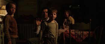 Movie still from “Cinderella Man” (2005), directed by Ron Howard – A man and a woman and a child in a dark room; Medium shot, Low angle