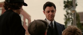 Movie still from “Cinderella Man” (2005), directed by Ron Howard – A man in a suit talking to two other men; Close Up shot, Over the shoulder angle
