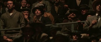 Movie still from “Cinderella Man” (2005), directed by Ron Howard – A group of people sitting in a crowd watching something; Medium shot, High angle