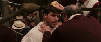 Movie still from “Cinderella Man” (2005), directed by Ron Howard – A man with a bunch of bananas on his head; Close Up shot, Over the shoulder angle