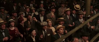 Movie still from “Cinderella Man” (2005), directed by Ron Howard – A group of men in suits and hats are sitting in a crowd; Medium shot, High angle
