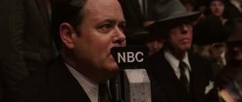 Movie still from “Cinderella Man” (2005), directed by Ron Howard – A person talking into a microphone; Close Up shot, Low angle