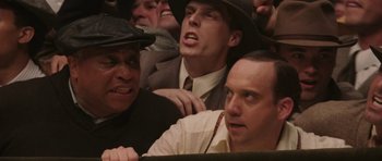Movie still from “Cinderella Man” (2005), directed by Ron Howard – A group of men sitting next to each other in a room; Close Up shot, Low angle