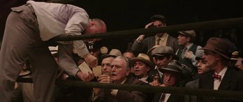 Movie still from “Cinderella Man” (2005), directed by Ron Howard – A group of people in a boxing ring; Wide shot, High angle