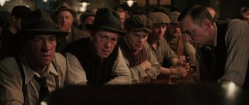 Movie still from “Cinderella Man” (2005), directed by Ron Howard – A group of men sitting at a table in front of drinks; Medium shot, Low angle