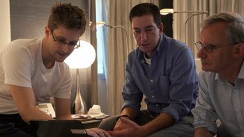 Movie still from “Citizenfour” (2014), directed by Laura Poitras – Two men are looking at a tablet computer together; Medium shot, Low angle