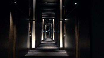 Movie still from “Citizenfour” (2014), directed by Laura Poitras – A dark hallway with lights on either side of it; Extreme Wide shot, Low angle