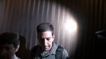 Movie still from “Citizenfour” (2014), directed by Laura Poitras – A man with a backpack is standing in front of a curtain; Close Up shot, Low angle