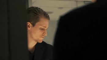 Movie still from “Citizenfour” (2014), directed by Laura Poitras – A person wearing a black suit; Close Up shot, Low angle