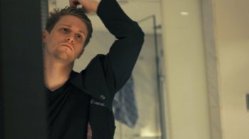 Movie still from “Citizenfour” (2014), directed by Laura Poitras – A man in black shirt brushing his hair in a mirror; Close Up shot, Low angle