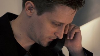 Movie still from “Citizenfour” (2014), directed by Laura Poitras – A person talking on a cell phone; Close Up shot, Low angle