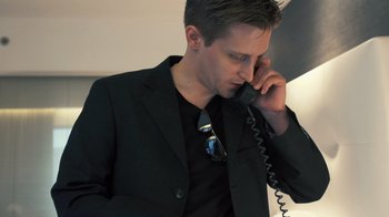 Movie still from “Citizenfour” (2014), directed by Laura Poitras – A man in a suit talking on a phone; Close Up shot, Low angle