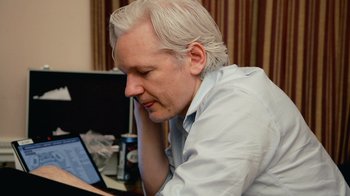 Movie still from “Citizenfour” (2014), directed by Laura Poitras – A man sitting at a table looking at a computer screen; Close Up shot, High angle