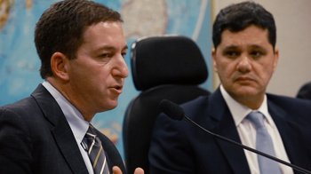 Movie still from “Citizenfour” (2014), directed by Laura Poitras – Two men in business suits are speaking at a press conference; Close Up shot, Over the shoulder angle