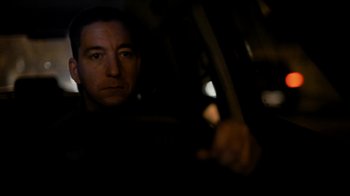Movie still from “Citizenfour” (2014), directed by Laura Poitras – A man sitting in the driver's seat of a car at night; Close Up shot, Low angle