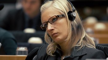 Movie still from “Citizenfour” (2014), directed by Laura Poitras – A woman wearing headphones and a black jacket; Close Up shot, High angle