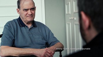 Movie still from “Citizenfour” (2014), directed by Laura Poitras – An older man sitting in front of another man in a chair; Medium shot, Over the shoulder angle