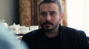 Movie still from “Citizenfour” (2014), directed by Laura Poitras – A person with a beard; Close Up shot, Over the shoulder angle