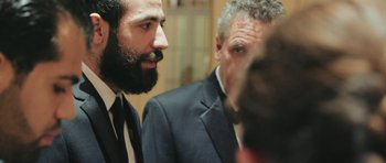 Movie still from “City of Ghosts” (2017), directed by Matthew Heineman – A man in a suit and a man in a tie; Close Up shot, Over the shoulder angle