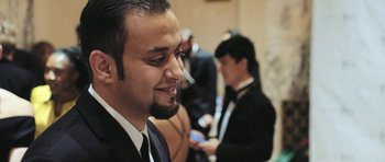 Movie still from “City of Ghosts” (2017), directed by Matthew Heineman – A person wearing a suit and tie; Close Up shot, Low angle