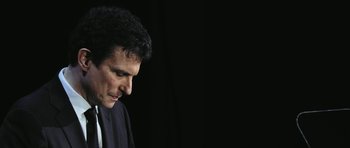 Movie still from “City of Ghosts” (2017), directed by Matthew Heineman – A person wearing a suit and tie; Close Up shot, Low angle