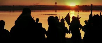 Movie still from “City of Ghosts” (2017), directed by Matthew Heineman – A group of people standing next to a body of water; Extreme Close Up shot, Low angle