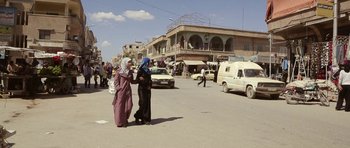 Movie still from “City of Ghosts” (2017), directed by Matthew Heineman – A couple of women walking down a street; Wide shot, Over the shoulder angle