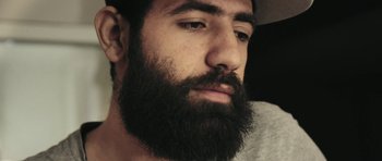 Movie still from “City of Ghosts” (2017), directed by Matthew Heineman – A person with a beard; Close Up shot, Low angle