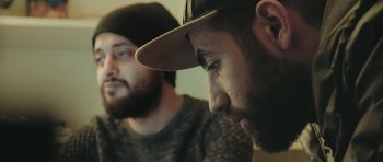 Movie still from “City of Ghosts” (2017), directed by Matthew Heineman – Two bearded men sitting next to each other in a room; Close Up shot, Low angle