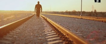Movie still from “City of Ghosts” (2017), directed by Matthew Heineman – A man is walking down a train track; Wide shot, Low angle