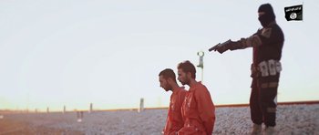 Movie still from “City of Ghosts” (2017), directed by Matthew Heineman – A couple of men standing next to each other on top of a hill; Wide shot, Low angle