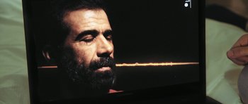 Movie still from “City of Ghosts” (2017), directed by Matthew Heineman – A man with a beard is looking down at the ground; Extreme Close Up shot, Over the shoulder angle