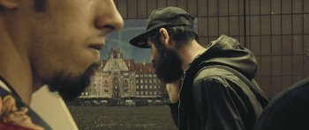 Movie still from “City of Ghosts” (2017), directed by Matthew Heineman – A man with a beard is looking at another man with a beard; Close Up shot, Low angle