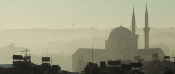 Movie still from “City of Ghosts” (2017), directed by Matthew Heineman – A view of a city skyline with a dome church in the background; Extreme Wide shot, Low angle
