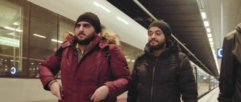 Movie still from “City of Ghosts” (2017), directed by Matthew Heineman – A couple of men standing next to each other; Medium shot, Low angle