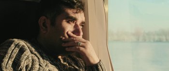 Movie still from “City of Ghosts” (2017), directed by Matthew Heineman – A person with his hand to his face; Close Up shot, Low angle