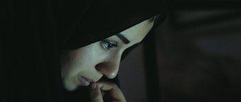 Movie still from “City of Ghosts” (2017), directed by Matthew Heineman – A person wearing a black headscarf; Close Up shot, Low angle