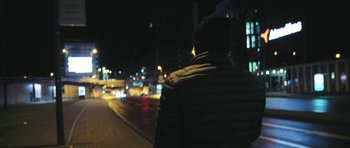 Movie still from “City of Ghosts” (2017), directed by Matthew Heineman – A man standing on the side of a road at night; Medium shot, Low angle