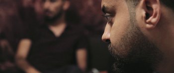 Movie still from “City of Ghosts” (2017), directed by Matthew Heineman – A person with a beard; Extreme Close Up shot, Over the shoulder angle