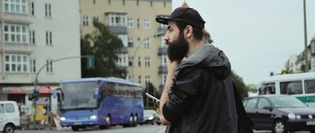 Movie still from “City of Ghosts” (2017), directed by Matthew Heineman – A man with a beard is holding a cell phone; Close Up shot, Low angle
