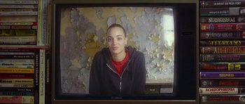 Movie still from “Climax” (2018), directed by Gaspar Noé – A young woman sitting on top of a television screen; Close Up shot, Over the shoulder angle